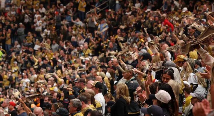 Crowd of sports fans cheering in stadium